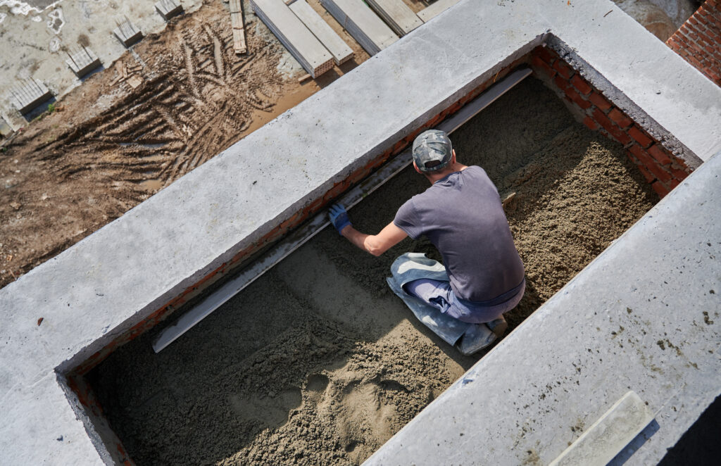 male worker screeding floor construction site